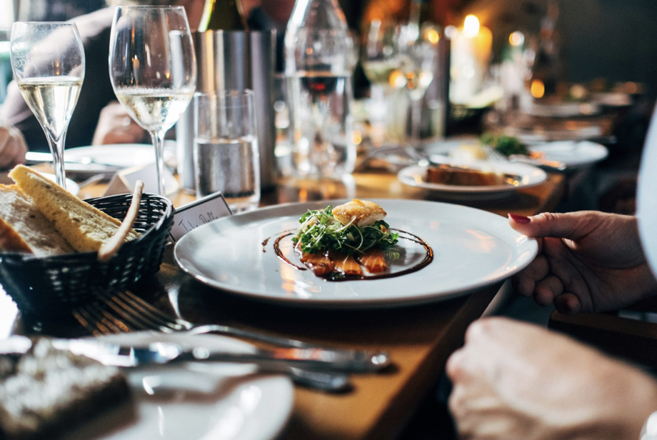 Fine dining at a restaurant with a large table, wine, and bread basket in Upper Mission